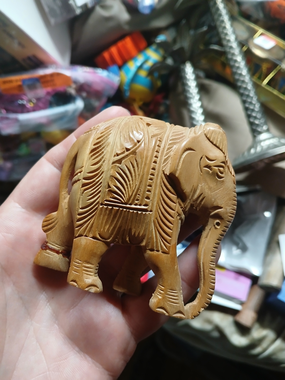 small, hand-carved wooden elephant figurine featuring intricate engraved pattern